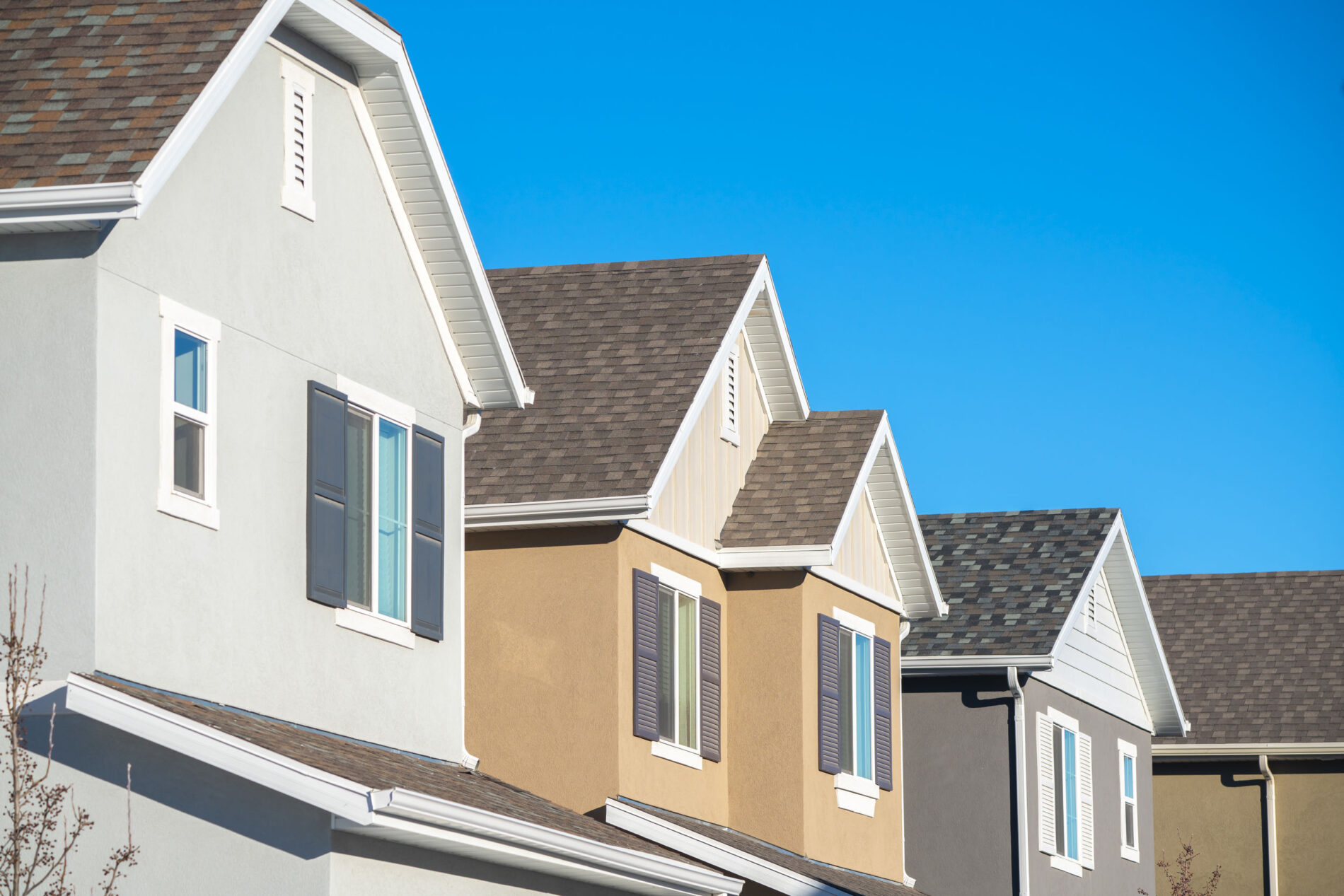 Rooflines of well-kept homes against a clear sky